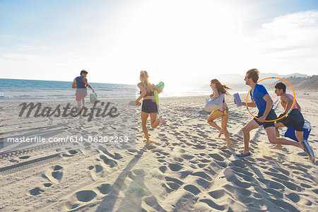 Group of friends running on beach, rear view