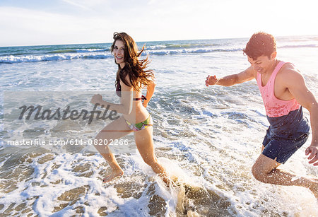 Young couple running in sea