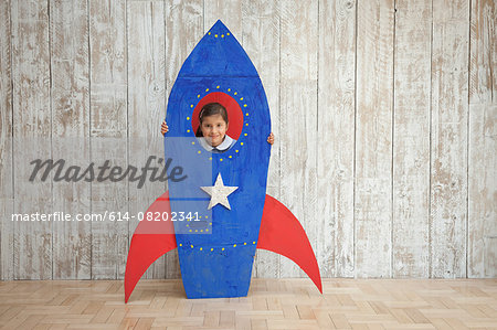 Portrait of girl looking from window of blue homemade cardboard rocket Portrait of girl looking from window of blue homemade cardboard rocket