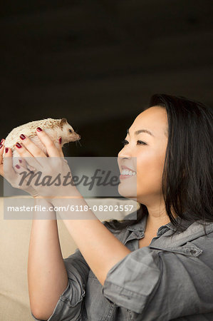 A woman holding a hedgehog in her hands.