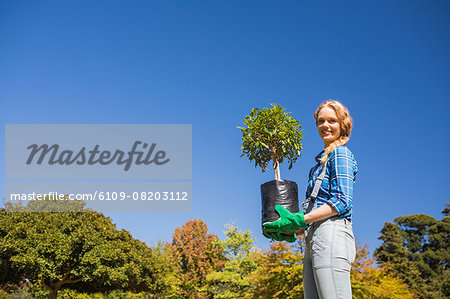 Happy woman holding potted flowers