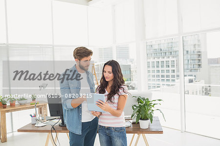 Casual business partners holding tablet