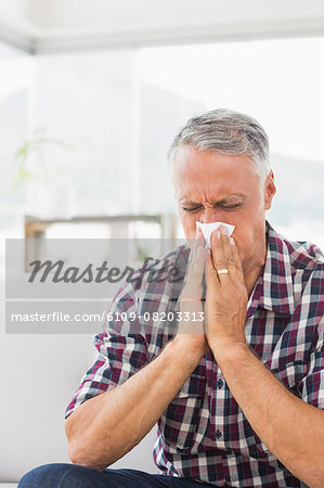 Sick businessman blowing his nose