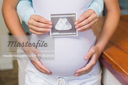 Lesbian girl showing her pregnant girlfriend sonogram