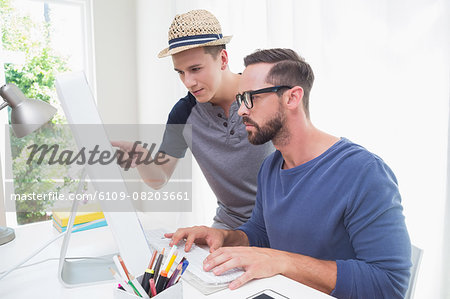 Happy homosexual couple working on computer