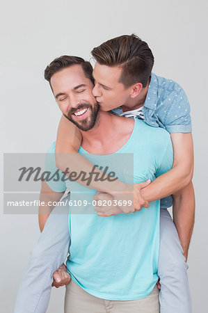 Happy homosexual couple kissing and having piggy back