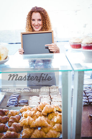 Happy pretty barista holding board