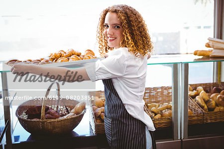 Happy pretty woman preparing plate with pastry