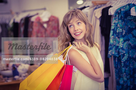 Woman thoughtful holding shopping bags