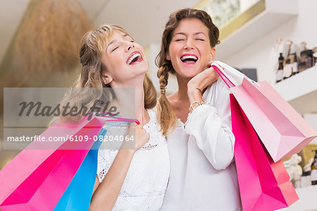 Beautiful women holding shopping bags laughing