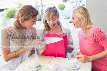 Beautiful women smiling and looking inside shopping bags