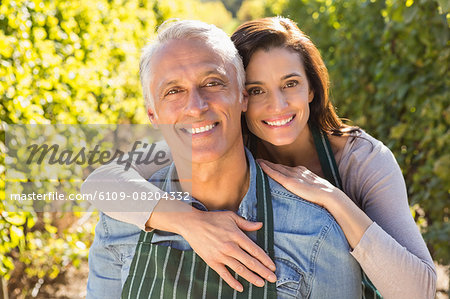 Embracing couple wearing aprons