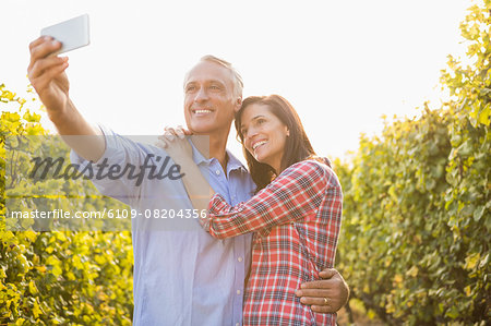 Happy couple embracing and taking selfies