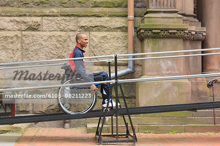 Man in wheelchair with Spinal Meningitis using a ramp