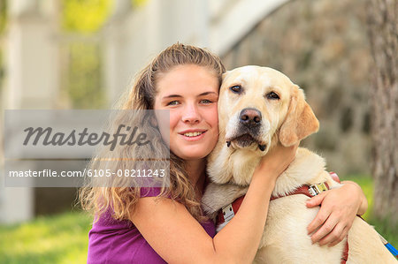 Woman with visual impairment hugging  her service dog