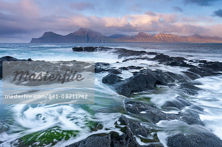 Waves crash against the rocky shores of Gjogv in the Faroe Islands, Denmark, Europe