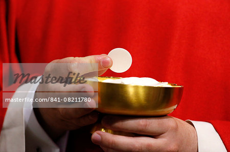 Catholic priest giving Holy Communion, Paris, France, Europe