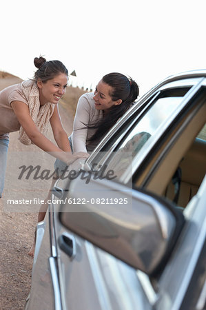 Girls pushing car