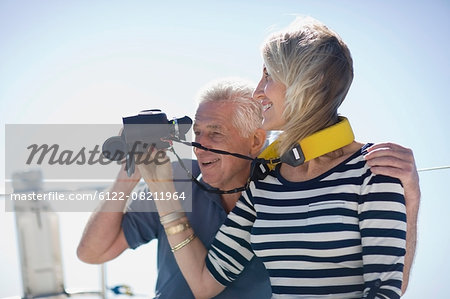 Older couple using binoculars on boat