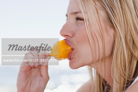 Woman eating popsicle on beach