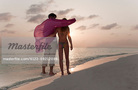 Couple playing on beach at sunset