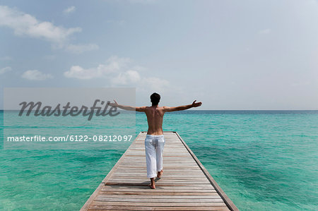 Man walking on deck overlooking sea