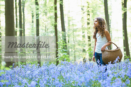 Girl with basket in field of flowers