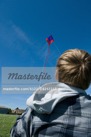 Boy flying a kite in field