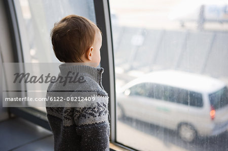 Boy looking through airport window