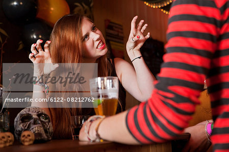 Young woman pulling faces at friend in bar