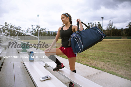 Soccer player placing sports bag on bench