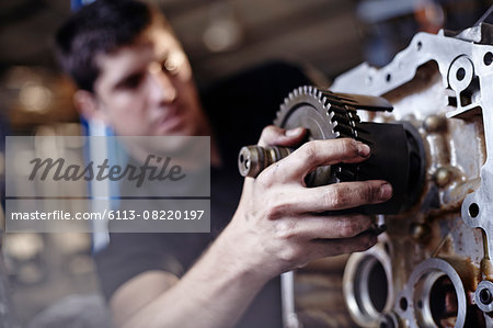 Close up mechanic fixing part in auto repair shop