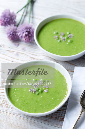 Still life of pea soup served with fresh chive and chive flowers