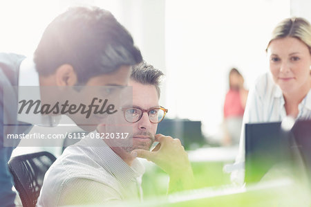 Business people working at computer in sunny office