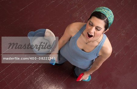 A woman tries to finish cleaning the floor by hand