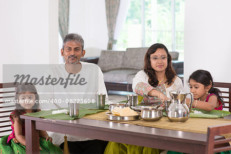 Indian family dining at home. Photo of India people eating rice on dining table. Traditional home cook meal.