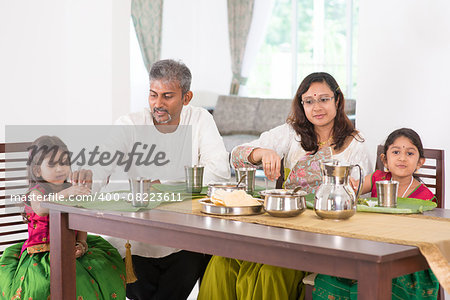 Indian family dining at home. Photo of Asian people eating rice with hands. India culture.