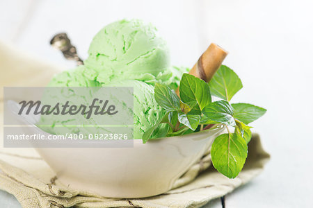 Scoop of matcha ice cream in bowl on wooden vintage background.