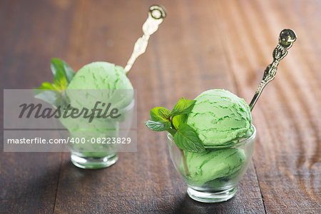 Scoop of matcha ice cream in cup on rustic old wooden vintage background.