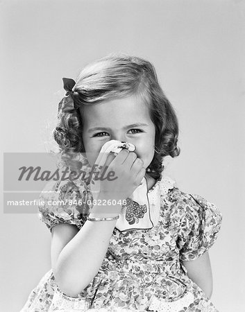 1940s LITTLE GIRL BLOWING HER NOSE WITH CLOTH HANDKERCHIEF