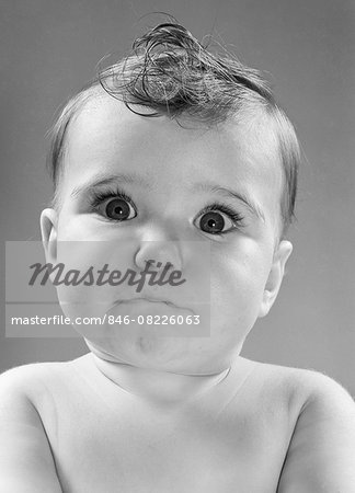 1950s BABY MAKING FUNNY FACE WITH WIDE OPEN EYES THIN MOUTH PURSED LIPS LOOKING AT CAMERA