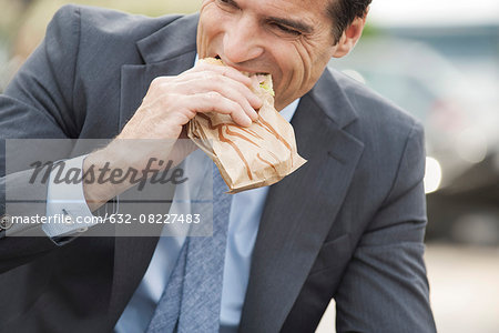 Businessman eating sandwich on the move