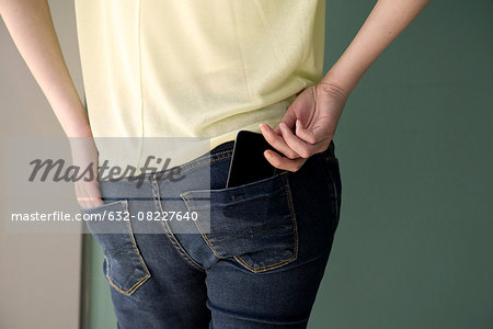Woman placing cell phone in back pocket Woman placing cell phone in back pocket