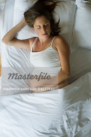 Pregnant woman sleeping in bed