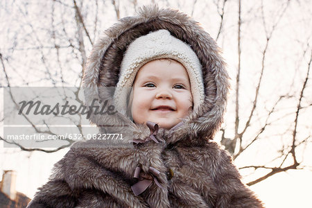 Baby girl wearing fur coat outdoors, portrait