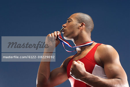 Athlete kissing medal outdoors