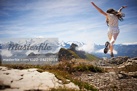 Girl jumping in rocky landscape