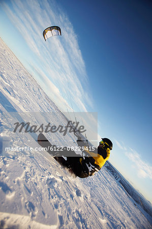 Man windsurfing on snowboard