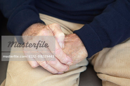 Close up of older man's folded hands