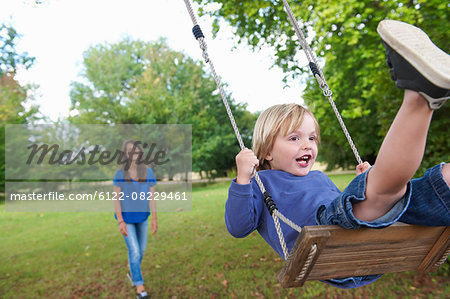 Boy playing on swing in backyard